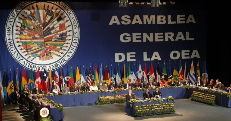 Vista de la última asamblea de la OEA con representantes de varios países en una sala de conferencias.