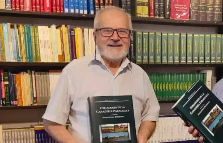 El periodista y escritor Efraín Martinez Cuevas, con un libro en la mano en una biblioteca.