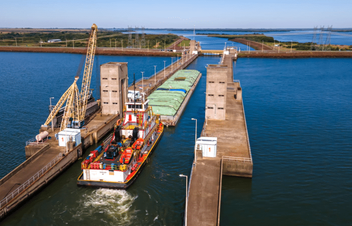 puerto fluvial con un barco en proceso de navegación.